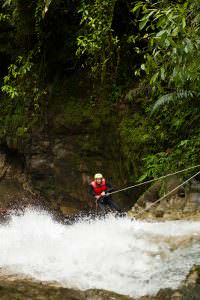 Adult Woman Wearing Waterproof Equipment Descending A Waterfall
