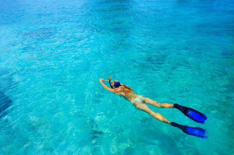Young woman ig snorkeling in tropical lagoon